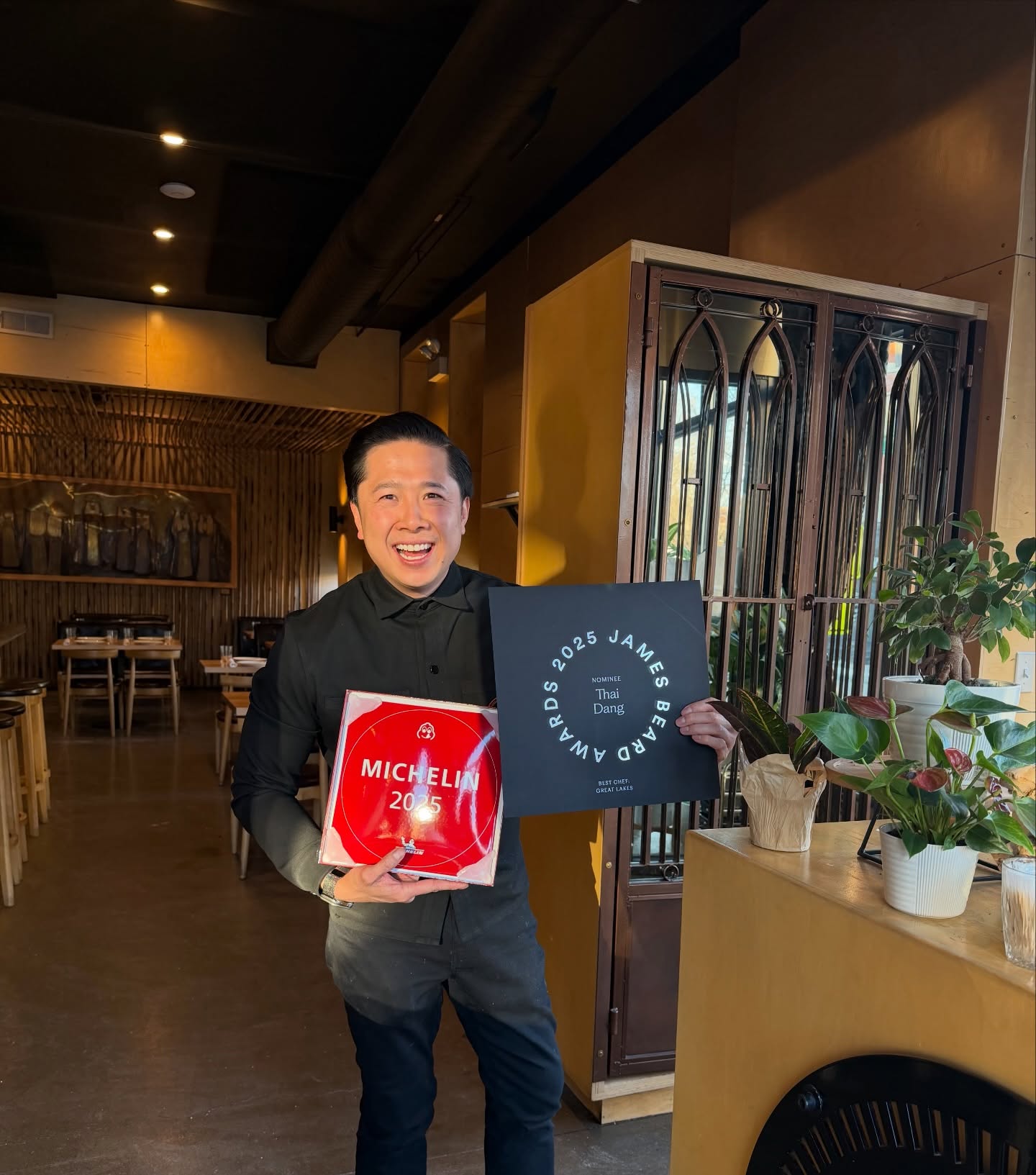 Chef Thai Dang holding his 2025 Michelin Bib Gourmand plaque and James Beard nomination